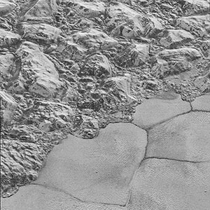  Mountains of ice along a portion of smoother ice planes on Pluto’s surface.